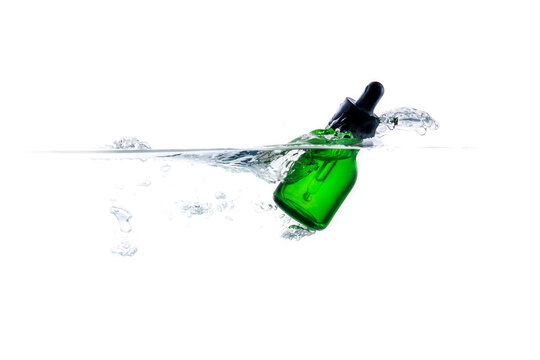 Green glass bottles with dropper splash of waterasia, background, bottle, celebration, color, concept, container, decoration, design, drink, dropper, equipment, glass, green, isolated, light, liquid, 