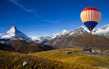 Aerial view of hot air balloon flying over Gornergrat in summer with scenic view of Matterhorn peak in background, Switzerland