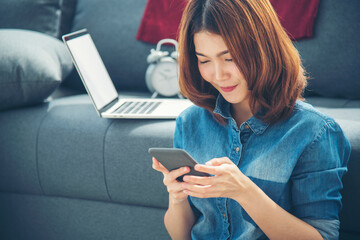 Smiling face asian woman holding smartphone with E-commerce Shopping online website Reading Online Article, Blog, vlog. Young Woman hands holding phone technology lifestyle. Woman using smart phone.