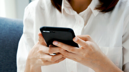 Smiling face asian woman holding smartphone with E-commerce Shopping online website Reading Online Article, Blog, vlog. Young Woman hands holding phone technology lifestyle. Woman using smart phone.