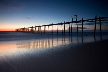 Fototapeta na wymiar Wooden bridge in the seaside with sunset