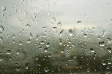 Rain drops on window glass on a heavy rainy day.