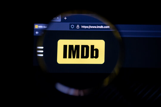 IMDb company logo on a website, seen on a computer screen through a magnifying glass.