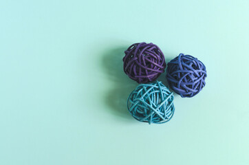 Three balls of colored thread on a colored background. Decor of colored threads on a light background of kopi space