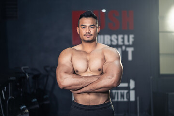 Fototapeta na wymiar Asian Fitness sportman bodybuilder crossed arm, look at camera in gym.