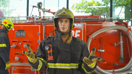 A Caucasian man firefighter or fireman with uniform talking to colleagues in webcam group video...