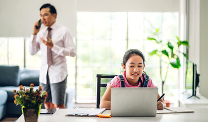 School kid little girl learning and looking at laptop computer making homework studying knowledge with online education e-learning system.children video conference with teacher tutor at home