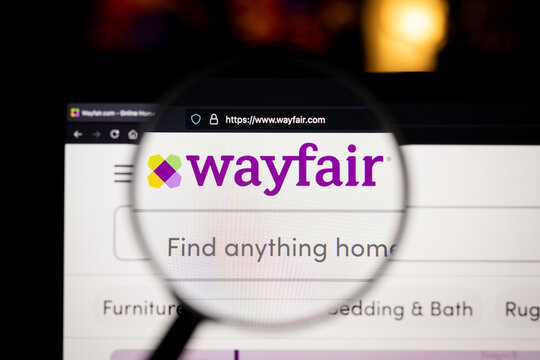 Wayfair company logo on a website, seen on a computer screen through a magnifying glass.