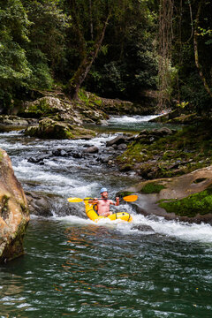Happy man shooting the rapids on Allyn River in an inflatable raft