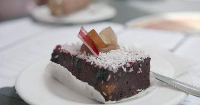 Maltese pastry Pudina served in restaurant in Malta. Traditional Maltese Kwarezimal feat bread pastry in Malta street caf&eacute;. A delicious chocolate cake served in a white plate on the wooden table.