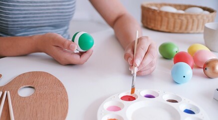 Woman painting Easter eggs at home. family preparing for Easter. Hands of a girl with a easter egg