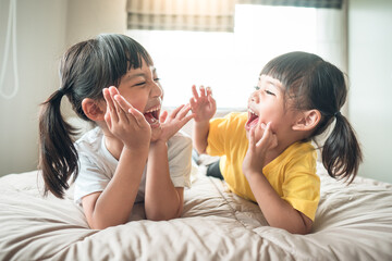 Cute asian children lying on the bed