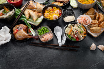 Assorted Chinese dishes and snacks on dark gray background. Traditional food concept.