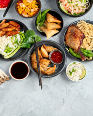 Assorted asian dishes and snacks on dark gray background. Traditional food concept.