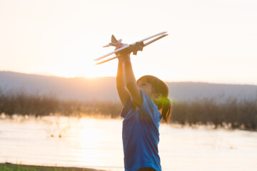 dreams of flight! child playing with toy airplane against the sky at sunset © FAMILY STOCK