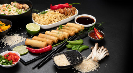 Assorted asian dishes and snacks on black background. Traditional food concept.