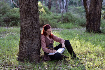 portrait of red haired girl wearing fantasy medieval clothes of a wandering adventurer.  natural light in a woodland forest setting.