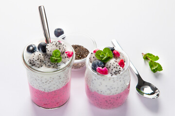 Layered chia puding with pink filling on white background.