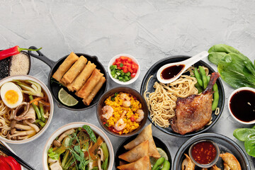 Assorted asian dishes and snacks on dark gray background. Traditional food concept.