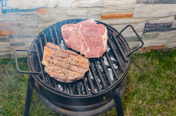 Marinated meat roasting on a grill in a home patio.