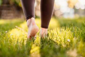 Woman walking barefoot on fresh green grass. Close up concept. Summer.