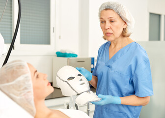 Doctor beautician applies mask to the patient for facial rejuvenation. High quality photo