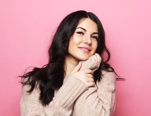 Young cute smiling brunette woman over pink background