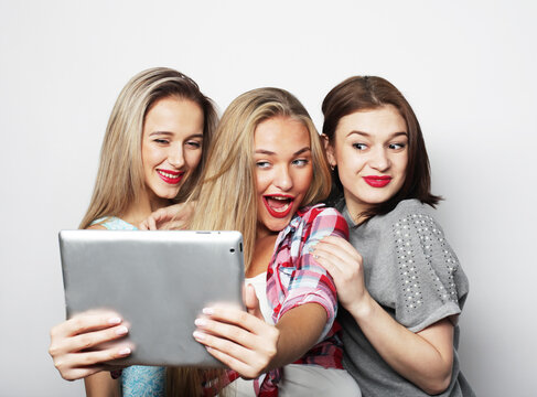 Three casual young female friends with digital tablet
