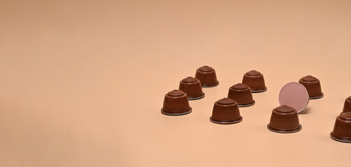 Coffee capsules on beige background.