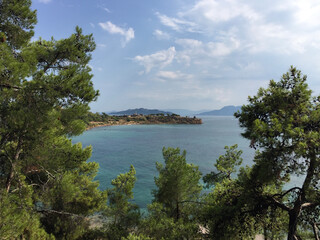 The remnant column of the Doric Temple of Apollo and the Hill of Kolona seen from a viewpoint on the coastal road on the island of Aegina, Greece.