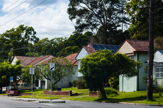 Keep left sign on road lined with homes in Newcastle