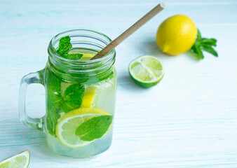 Glass mug of non-alcoholic mojito on a wooden table and ingredient on the background. Mojito...