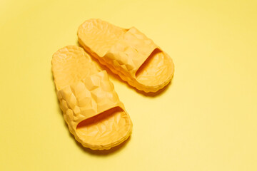 Close-up of yellow slippers on yellow background.