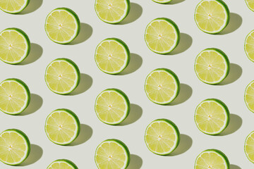 Texture made with slices of lime isolated on a bright white background. A pattern of citrus fruit...