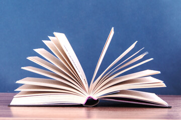 open book on the table against blue background
