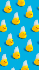Pattern of rubber and squeaky ducklings on a bright blue background. Minimal bath time with foam...