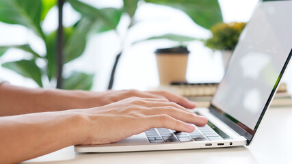 Close up of man hand typing laptop computer while working at home office, Student college online study, learning, people and technology
