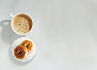 top angle of Porcelain cup of tea and donuts on plate isolated on white background with copy space
