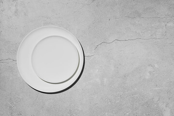 Overhead view of two plates over concrete background