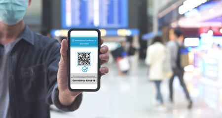 Vaccine passport, Traveler shows health passport of vaccination certification on mobile phone via mobile app at international airport, to certify that have been vaccinated of coronavirus covid-19