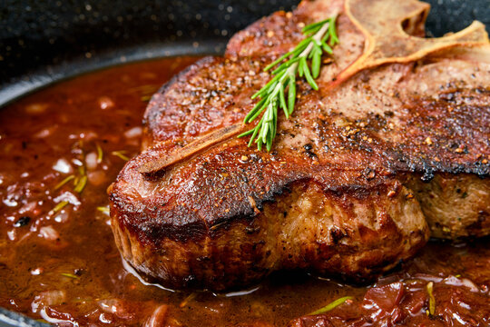 Closeup view of Porterhouse steak in wine sauce