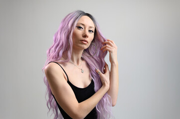 Portrait of a fashionable Caucasian girl with pink hair on a white background.