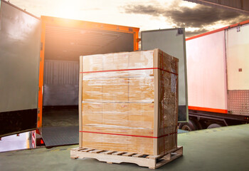 Stacked of Package Boxes on Pallet Load with Cargo Container. Trucks Parked Loading at Dock Warehouse. Delivery Service. Shipping Warehouse Logistics. Road Freight Truck Transportation.	