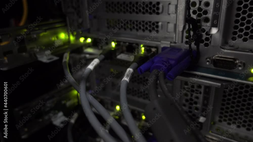 Poster back of the server installed in the server room. many cables blink led lamp.