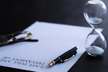 Sand running through the bulbs of an hourglass measuring the passing time in a countdown to a...