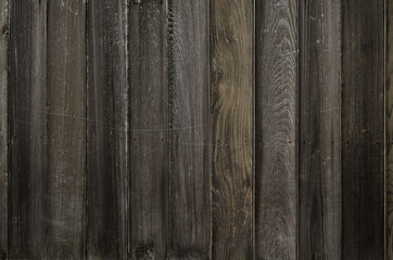 Texture of dark wooden board wall weathered by UV rays