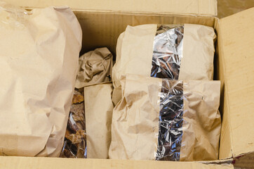 Pet treats in brown paper bags with window. A cardboard box full