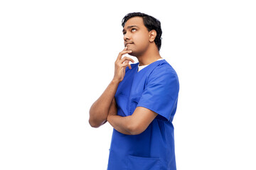 healthcare, profession and medicine concept - thinking indian doctor or male nurse in blue uniform...