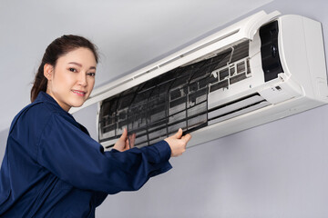 female technician service removing air filter of air conditioner for cleaning