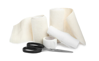 Medical bandage rolls, sticking plaster and scissors on white background